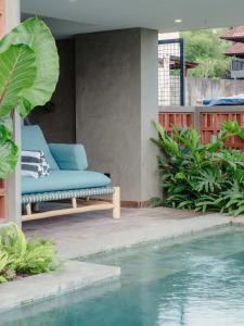 a patio with a blue couch next to a swimming pool at Tarate Loft Studio Ubud in Ubud