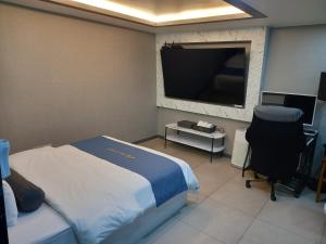 a bedroom with a bed and a flat screen tv at On & Off Hotel Bupyeong in Incheon