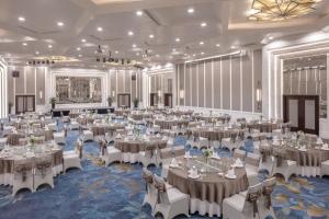 um salão de banquetes com mesas e cadeiras numa sala em Melia Hanoi em Hanói