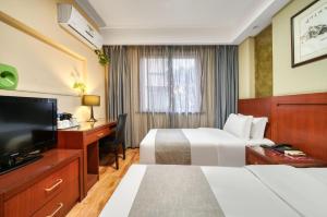 um quarto de hotel com duas camas e uma televisão de ecrã plano em Hangzhou Bokai Westlake Hotel em Hangzhou