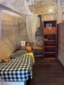 a man laying on a bed in a bedroom at Seabreeze Hostel Bali in Canggu