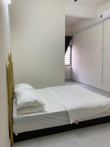 a bedroom with a bed with white sheets and a window at Juwita&Arjuna Homestay Teluk Senangin 
