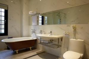 y baño con bañera, lavabo y aseo. en Holiu Resort en Nan-p'ing-li