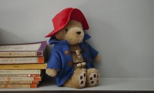 a teddy bear sitting next to a pile of books at The Laslett in London