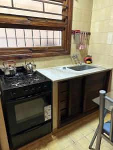a kitchen with a stove and a sink at CASA ELENA in Mar del Plata