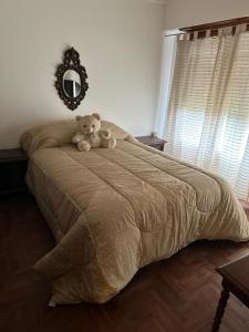 a teddy bear sitting on top of a bed at CASA ELENA in Mar del Plata