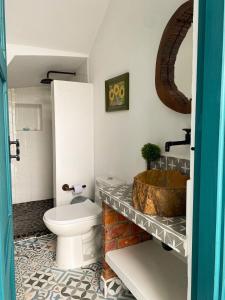 a bathroom with a toilet and a wooden sink at Casa en Cauca Viejo con piscina, Jacuzzi y aire acondicionado in Jericó