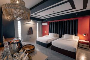 Cette chambre comprend deux lits et un lustre. dans l'établissement Havitat Boutique Hotel, à Manille