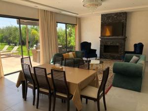 a living room with a table and chairs and a fireplace at Private Villa with private Chef optional in Marrakesh