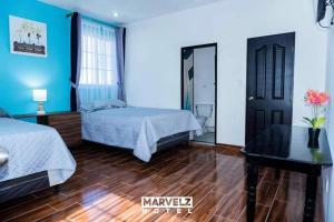 a bedroom with two beds and a mirror at Marvelz Hotel 