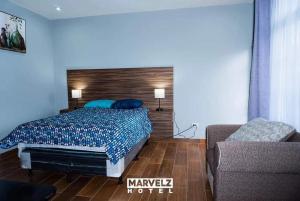 a bedroom with a bed and a couch at Marvelz Hotel 