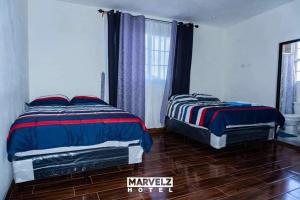 sypialnia z 2 łóżkami i oknem w obiekcie Marvelz Hotel 