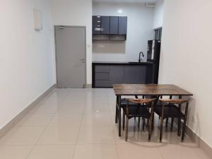 a kitchen with a table and chairs and a refrigerator at RC Firdaus Homestay Kuala Lumpur in Kuala Lumpur
