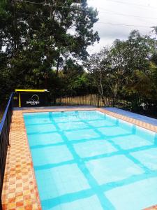 a large swimming pool with a blue at Amalaya Hostel in Restrepo
