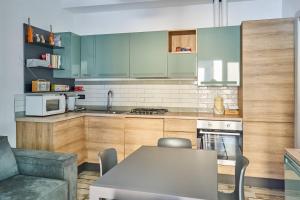 eine Küche mit grünen Schränken, einem Tisch und einer Couch in der Unterkunft appartamento a due passi dal mare in Bellaria-Igea Marina