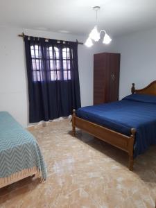 um quarto com uma cama, uma cómoda e uma janela em Casa La Puntilla em Malargüe
