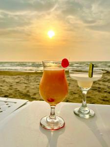 a drink sitting on a table on the beach at Caribbean Escape Lodge in San Silvestre