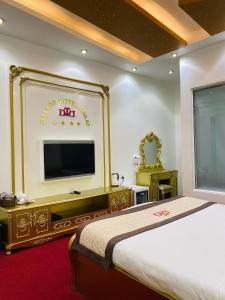 a hotel room with a bed and a flat screen tv at Dallas Hotel Dalat in Da Lat