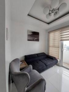 sala de estar con sofá negro y sillas en Budget Family Room w FREE pool access in Manila, en Manila