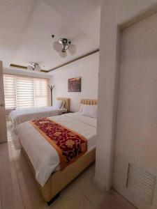 1 dormitorio con 2 camas individuales en una habitación en Budget Family Room w FREE pool access in Manila, en Manila