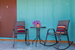 twee stoelen en een tafel met een vaas met bloemen bij NUESTROS SUEÑOS in Santa Cruz