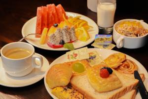 a table with three plates of food and a cup of coffee at Doubletree By Hilton Quzhou in Quzhou