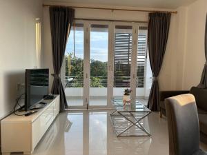 a living room with a television and a glass table at 2 Bedroom Seaview Lanta Sport Resort 303 in Phra Ae beach