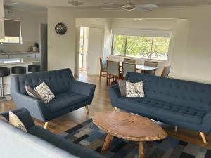 uma sala de estar com dois sofás azuis e uma mesa em Portarlington Beach Motel em Portarlington