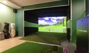 仁川的住宿－On & Off Hotel Bupyeong，一间配有电视的客房,墙上设有高尔夫球模拟器