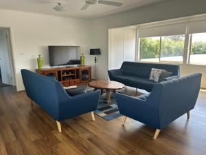 un soggiorno con divani blu e TV di Portarlington Beach Motel a Portarlington