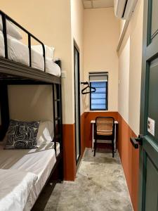 a room with two bunk beds and a chair at Swing & Pillows @ Muntri in George Town