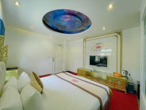 a bedroom with a large bed and a tv at Dallas Hotel Dalat in Da Lat