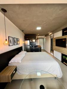 a bedroom with a large bed and a glass table at Studio Estilo Industrial +Espaço in Mossoró