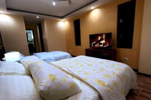 a bedroom with two beds and a flat screen tv at Your Home Away From Home ! in Ambato
