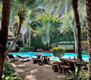 een patio met tafels en banken naast een zwembad bij Apartment with endless mountain view, Pearl 803 in Rawai Beach