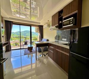 een keuken met een tafel en een raam met uitzicht bij Apartment with endless mountain view, Pearl 803 in Rawai Beach