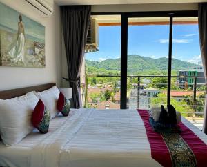 een slaapkamer met een groot bed en een groot raam bij Apartment with endless mountain view, Pearl 803 in Rawai Beach