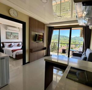 een slaapkamer met een bed en een bureau in een kamer bij Apartment with endless mountain view, Pearl 803 in Rawai Beach