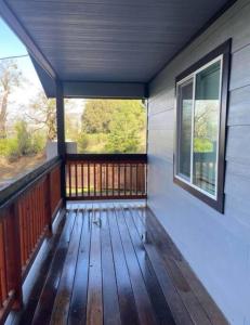un porche de una casa con terraza y ventana en New, Fun-Size Benbow House!, en Garberville