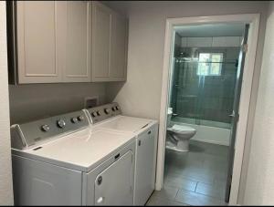 a bathroom with a washing machine and a toilet at New, Fun-Size Benbow House! in Garberville +17 photos