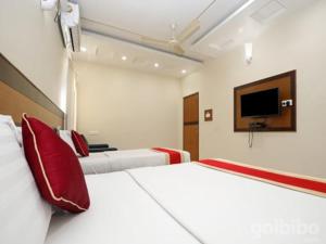 a hotel room with two beds and a flat screen tv at HLVGRANDINN in Bangalore