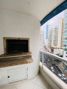 a balcony with a fireplace in a building with a city at Apto à 100m da praia central in Balneário Camboriú