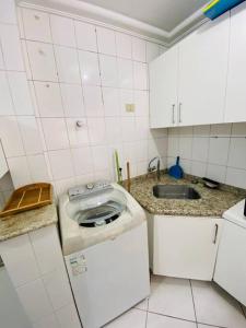 a small kitchen with a sink and a toilet at Apto à 100m da praia central in Balneário Camboriú