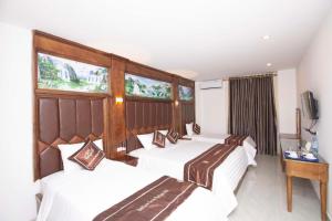 a hotel room with three beds and a television at Vientiane Garden Villa Hotel And Restaurant in Vientiane