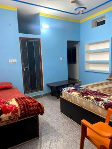 瓦拉納西的住宿－Garuda Guest House，蓝色的客房配有两张床和一张桌子