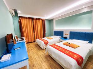 a hotel room with two beds and a television at Mount Emei Teddy Bear Hotel玩具熊酒店 in Emeishan