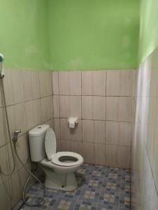 La salle de bains est pourvue de toilettes et d'un mur vert. dans l'établissement Nadil Homestay, à Kuta Lombok 46 autres photos