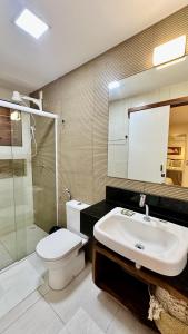 a bathroom with a toilet and a sink and a shower at Apê Jardins in Flecheiras