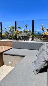 a bench on top of a building with palm trees at Apê Jardins in Flecheiras