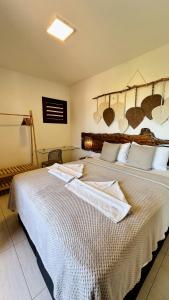 a bedroom with a large bed with towels on it at Apê Jardins in Flecheiras